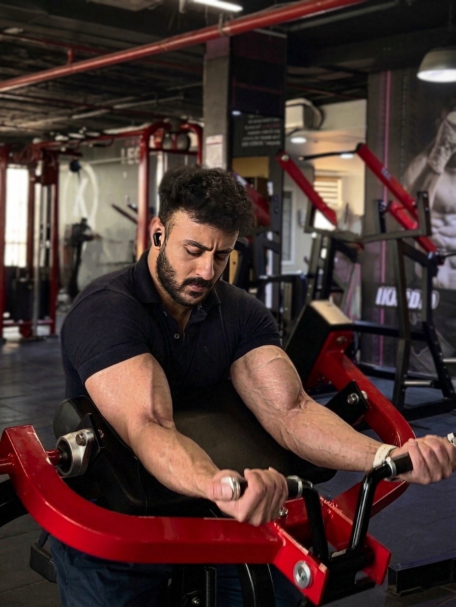 Dagher Mahmoud mid-set on a weight machine.